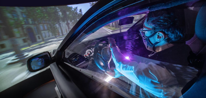 a man turning the steering wheel in a driving simulator
